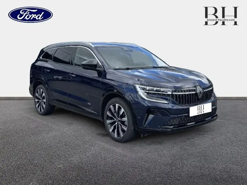 Renault Espace bleu foncé en 3/4 avant droit, avec calandre verticale distinctive et jantes alliage modernes.