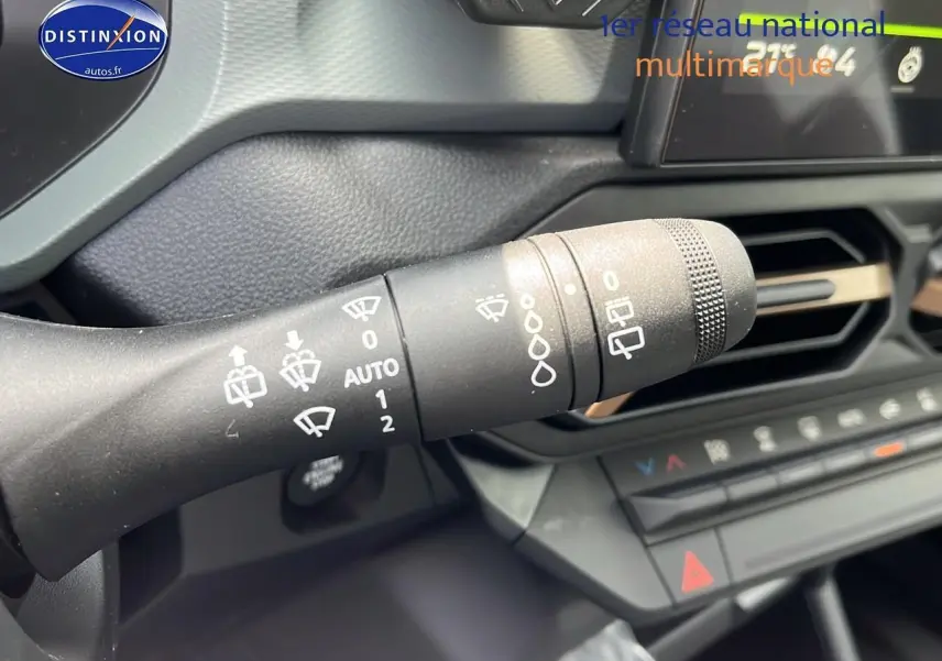 Gros plan sur la commande d'essuie-glace du tableau de bord noir du Dacia Duster 2025.