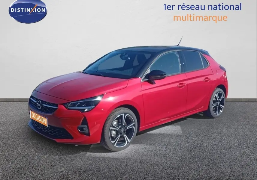 Opel Corsa rouge Kardio métal avec toit noir vue 3/4 avant droit, jantes alliage noires et phares LED allumés.