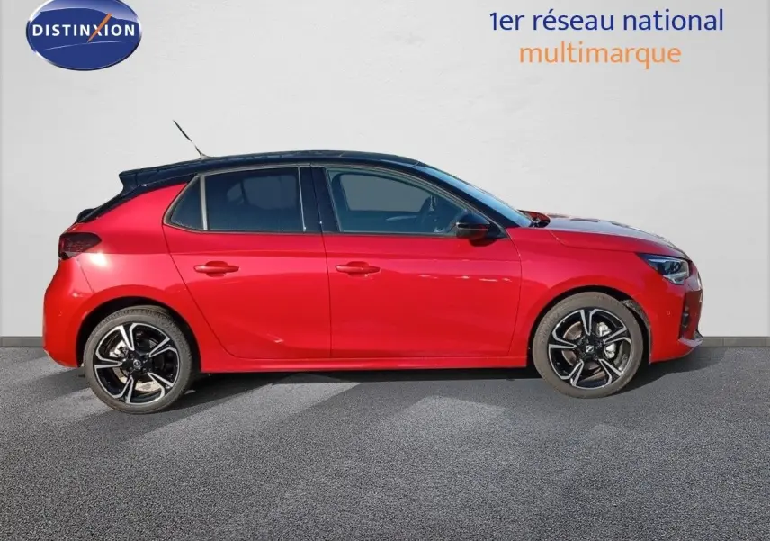 Profil gauche d'une Opel Corsa 2023 rouge Kardio métal avec toit noir et jantes alliage bicolores.