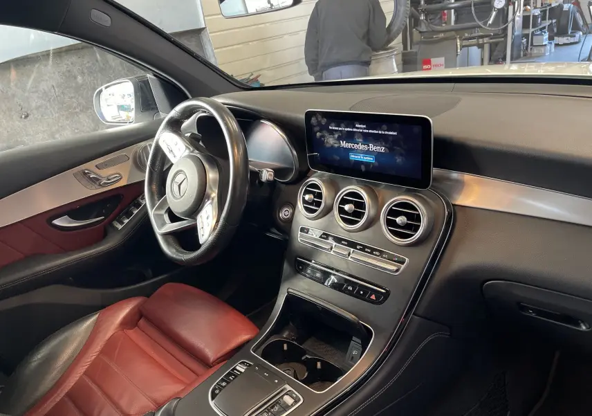 Intérieur avant droit du Mercedes GLC Coupé blanc 2019, sièges cuir rouge, tableau de bord moderne avec écran central.