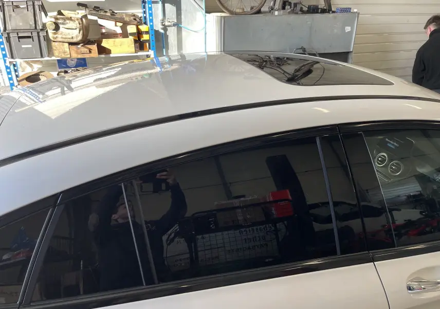 Vue latérale côté gauche du Mercedes GLC Coupé blanc 2019 avec toit ouvrant panoramique et vitres teintées.