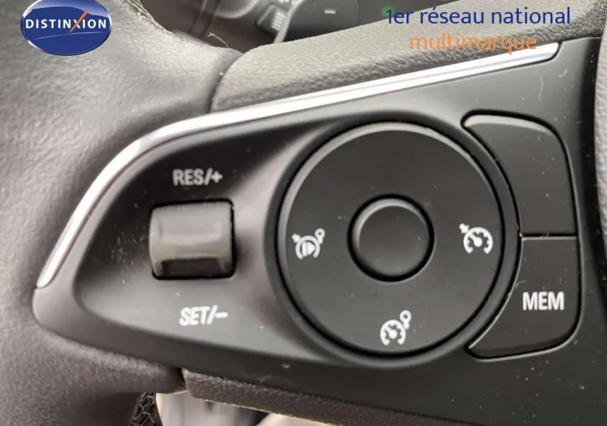 Gros plan sur les commandes au volant noir de l’Opel Grandland X 2021, version hybride, avec boutons de régulateur de vitesse.