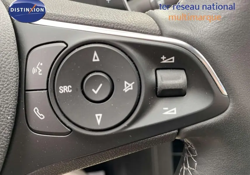 Gros plan sur les commandes du volant noir de l'Opel Grandland X 1.6 Hybrid Turbo 2021, avec boutons multifonctions.