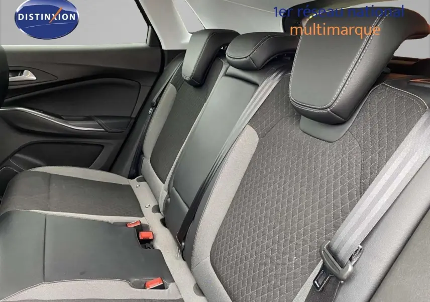 Vue intérieure du siège arrière droit de l’Opel Grandland X 2021, tissu gris et cuir noir avec ceintures de sécurité visibles.