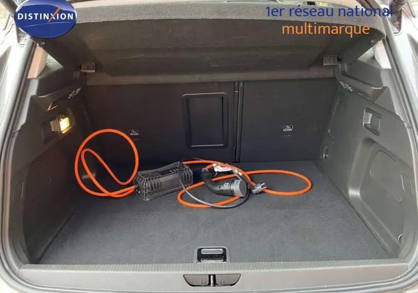 Coffre ouvert d’un Opel Grandland X 1.6 Hybrid Turbo 2021, vue arrière, avec câble de recharge orange visible.
