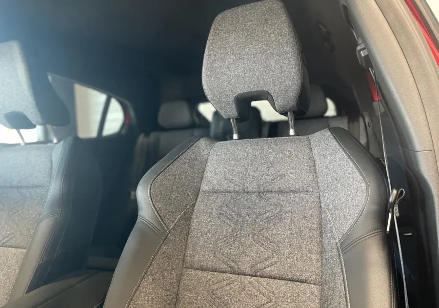 Gros plan sur le siège avant droit gris textile et cuir noir avec surpiqûres, intérieur du Renault Rafale rouge visible.