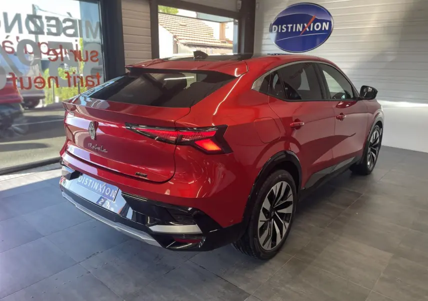 Vue 3/4 arrière droite d'une Renault Rafale rouge à toit noir, avec feux LED et jantes alliage noires.
