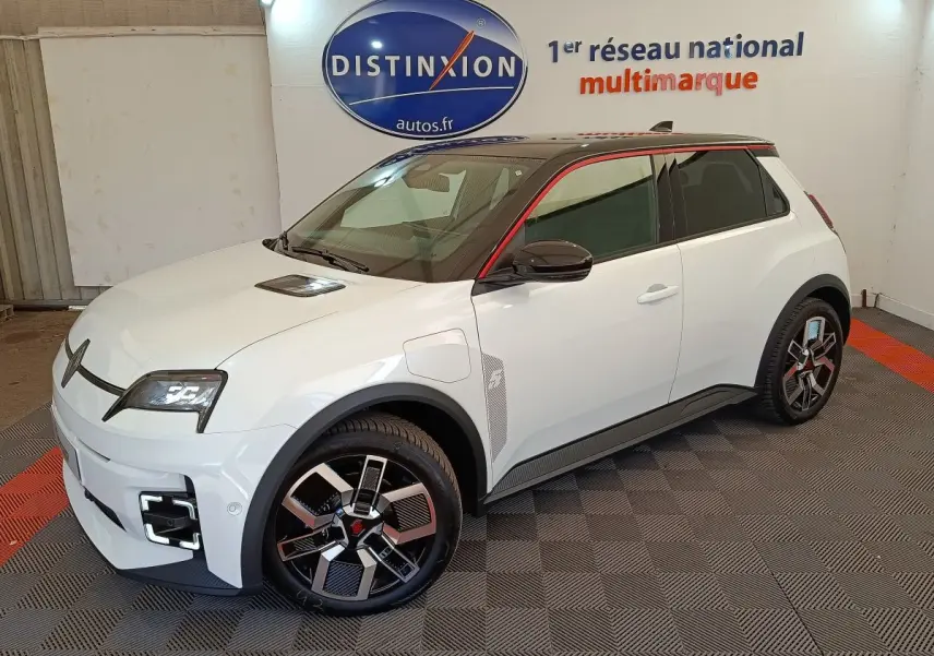 Vue 3/4 avant droit d'une Renault R5 Techno blanche avec toit noir et jantes au design moderne.