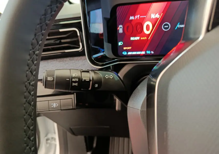 Vue rapprochée du combiné d’instruments digital rouge et noir et du commodo gauche sur Renault R5 Techno blanc 2025.