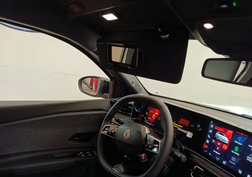 Vue intérieure côté conducteur de la Renault R5 Techno 150 ch blanc, avec volant multifonctions et écran tactile large.