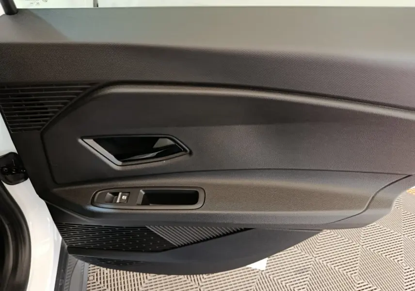 Vue rapprochée de la porte intérieure côté gauche blanche de la Renault R5 Techno 150 ch avec poignée noire et commande de vitre.