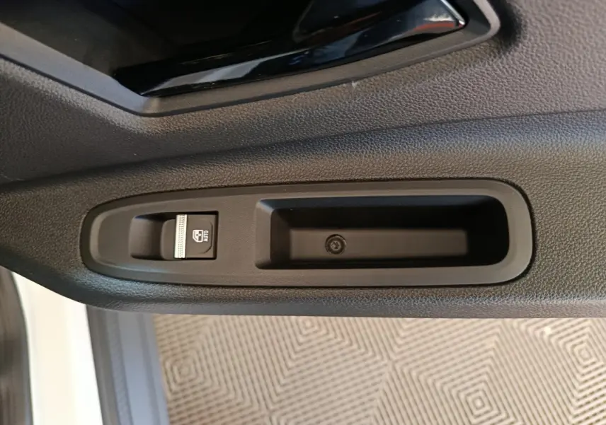 Détail de la commande de lève-vitre côté conducteur sur porte intérieure noire de Renault R5 Techno 2025 blanc.