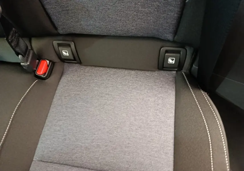 Détail de la banquette arrière grise avec fixation Isofix et ceinture rouge dans une Renault R5 Techno 2025.