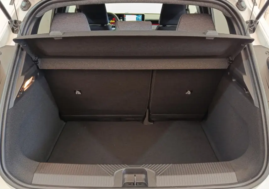 Vue du coffre arrière ouvert d'une Renault R5 Techno 150 ch blanc, avec banquette arrière rabattable 2/3-1/3 visible.