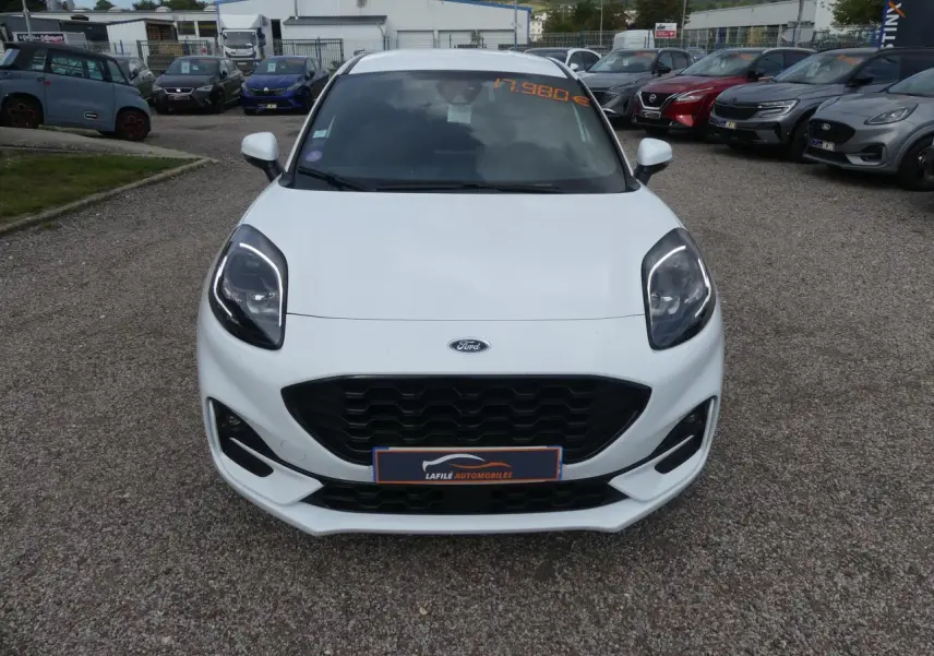 Vue avant d'une Ford Puma blanche ST Line avec calandre noire et phares LED, stationnée en extérieur.