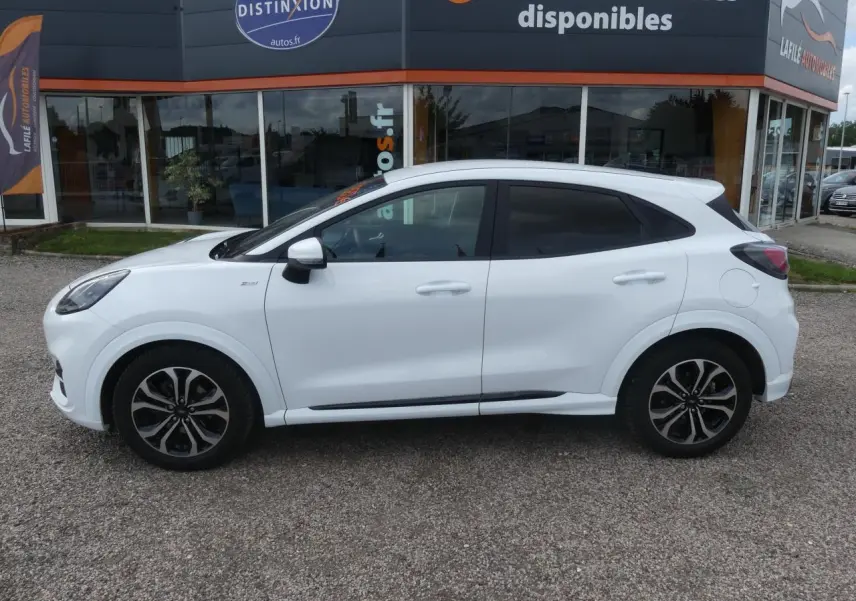 Vue latérale droite d'un Ford Puma blanc avec vitres arrière surteintées et jantes alliage noires.