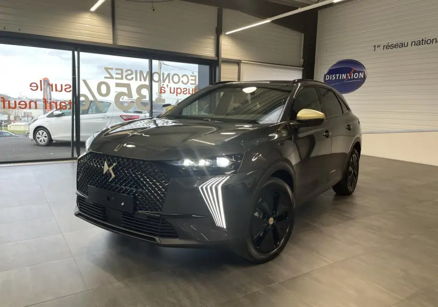 DS7 Crossback gris titanium en 3/4 avant droit, avec calandre noire brillante et coques de rétroviseurs dorées satinées.