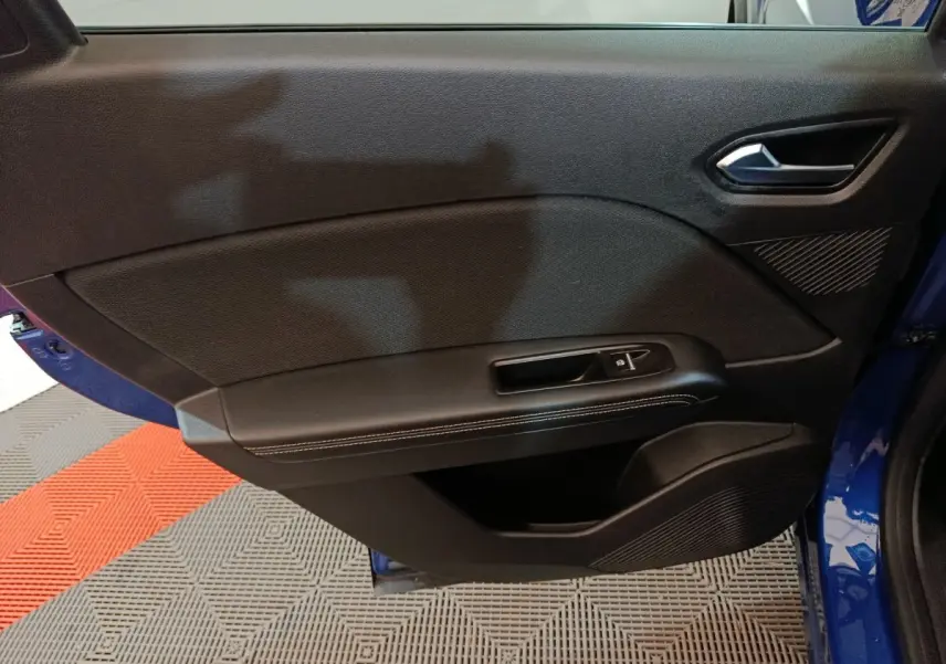 Vue rapprochée de la porte avant gauche bleu Renault Symbioz 2025, avec commande de vitre et garniture noire.