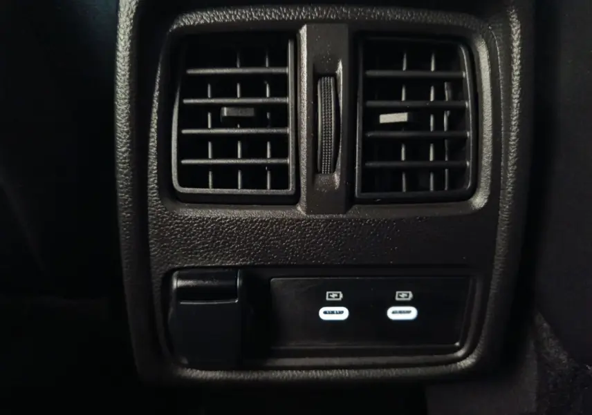 Vue rapprochée des prises USB et des aérateurs arrière noirs du Renault Symbioz Iconic E-Tech bleu 2025.