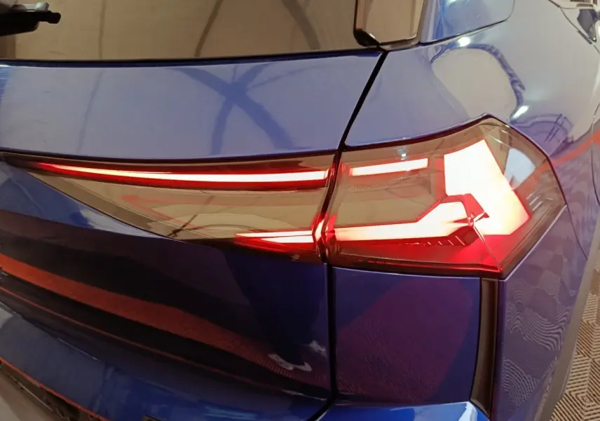 Feu arrière droit allumé sur Renault Symbioz bleu, vue rapprochée du coin arrière du véhicule.