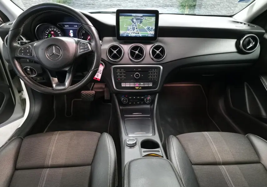 Vue intérieure avant de la Mercedes GLA 220 d 2017, tableau de bord noir avec écran central et volant multifonctions.