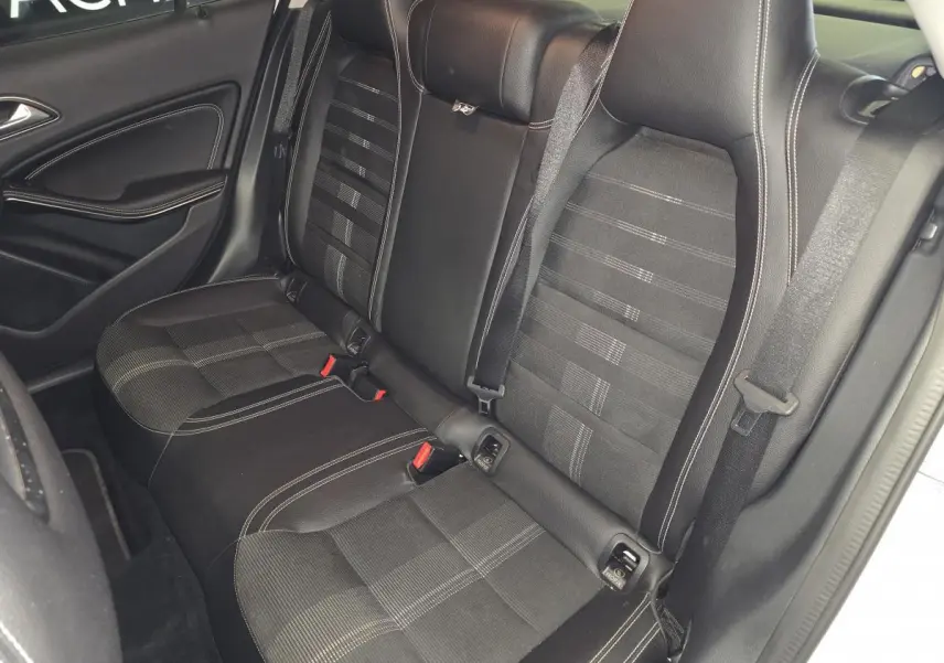 Vue intérieure côté gauche des sièges arrière noirs avec surpiqûres blanches d'une Mercedes GLA 220 d Sensation 4-Matic 2017.