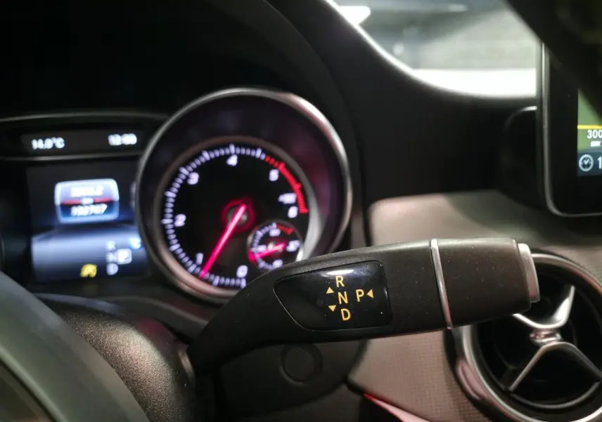 Gros plan sur la commande de boîte automatique avec tableau de bord et aérateur rond du Mercedes GLA blanc 220 d Sensation 2017.