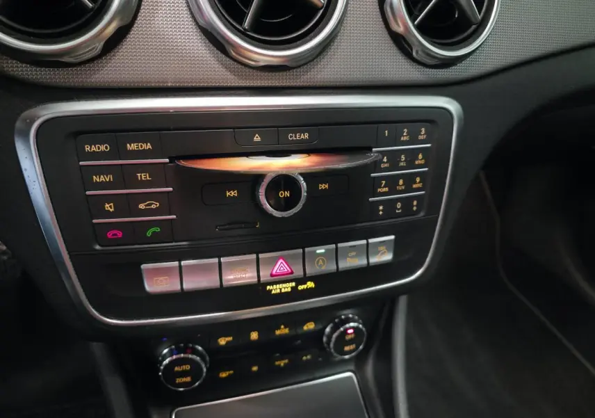 Vue rapprochée du tableau de bord noir et argenté du Mercedes GLA 220 d 2017 avec commandes multimédia et climatisation.