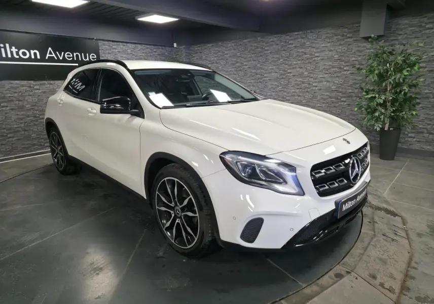 Mercedes GLA 220 d blanc en 3/4 avant droit, avec jantes alliage noires et rétroviseurs noirs brillants.