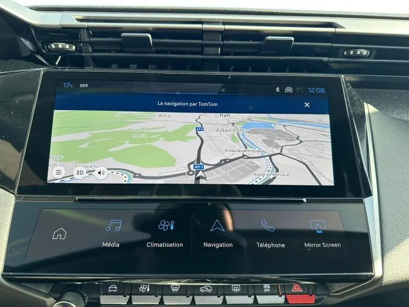 Vue rapprochée de l'écran tactile central noir affichant la navigation dans l'habitacle d'une Peugeot 308 bleu.