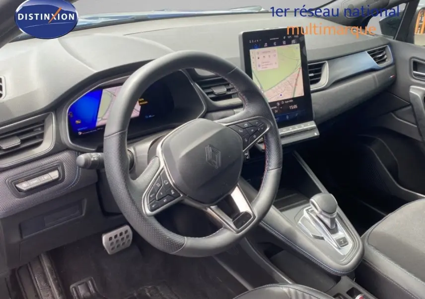 Intérieur de la Renault Symbioz 2025 en vue de côté gauche, volant cuir, écran tactile vertical et console centrale moderne.