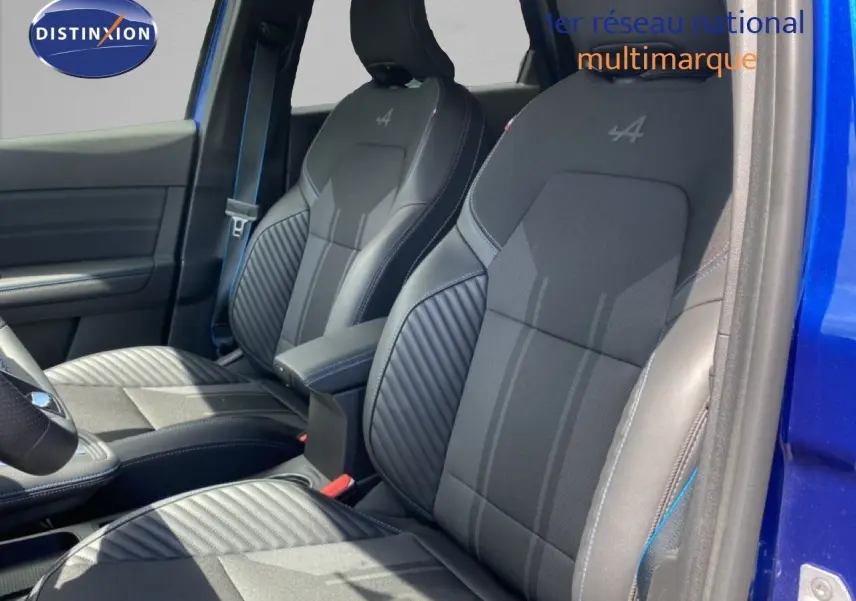 Vue intérieure côté conducteur montrant les sièges noirs avec logo Alpine sur une Renault Symbioz bleu iron metal.