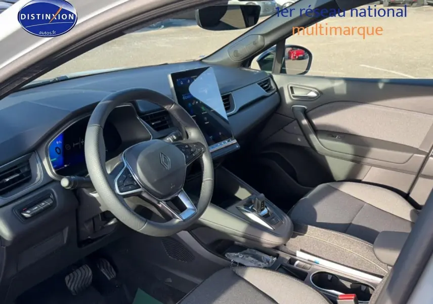 Vue intérieure côté conducteur du Renault Symbioz gris rafale, avec écran tactile vertical et volant multifonction.