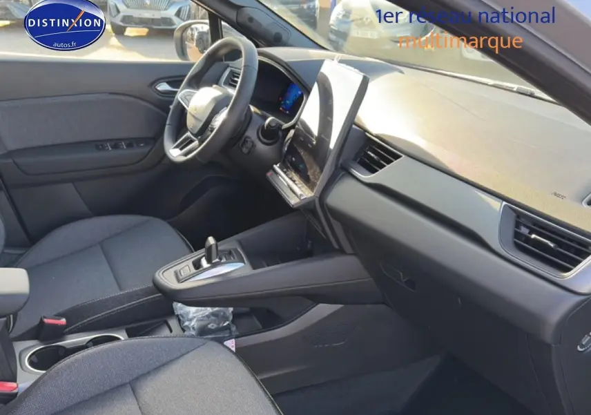 Intérieur avant droit de la Renault Symbioz gris rafale, avec tableau de bord moderne et écran tactile vertical.