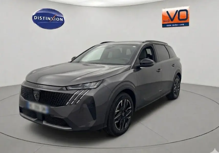 Peugeot 5008 Hybrid gris 2025 en 3/4 avant droit, avec calandre noire et jantes alliage distinctives.