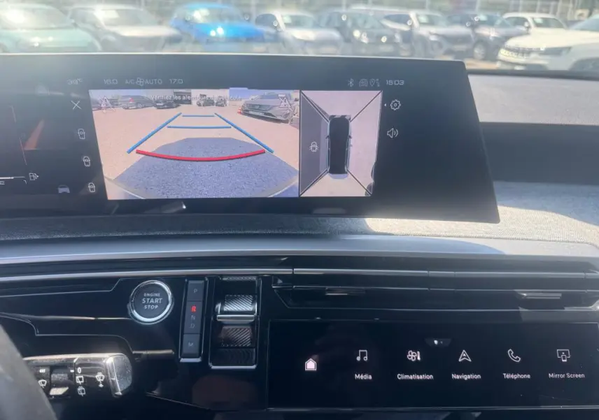 Vue intérieure du tableau de bord du Peugeot 5008 Hybrid gris, avec écran multimédia affichant la caméra de recul et les commandes tactiles.