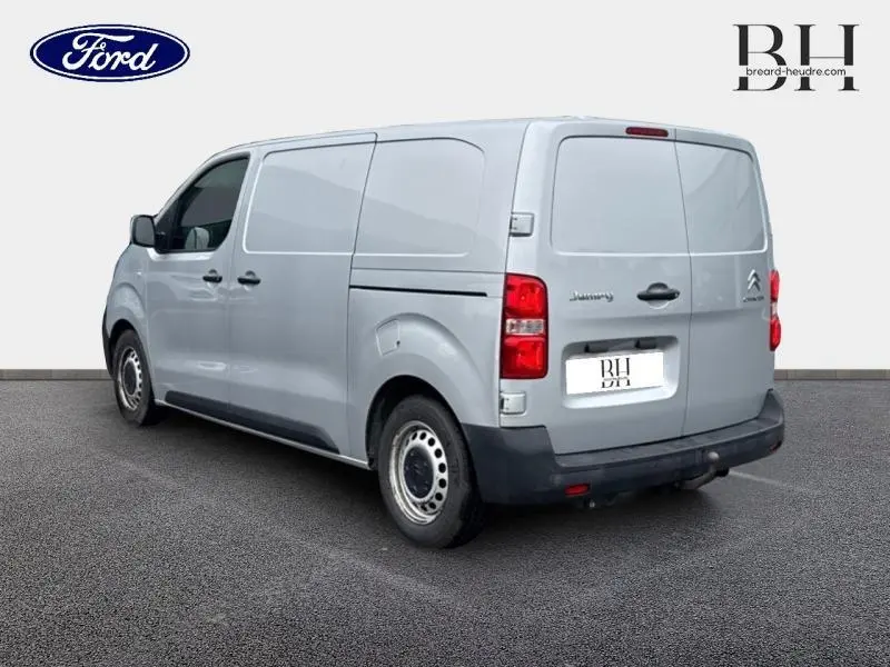 Vue 3/4 arrière droite du Citroën Jumpy gris aluminium, fourgon utilitaire avec portes arrière pleines et jantes acier.