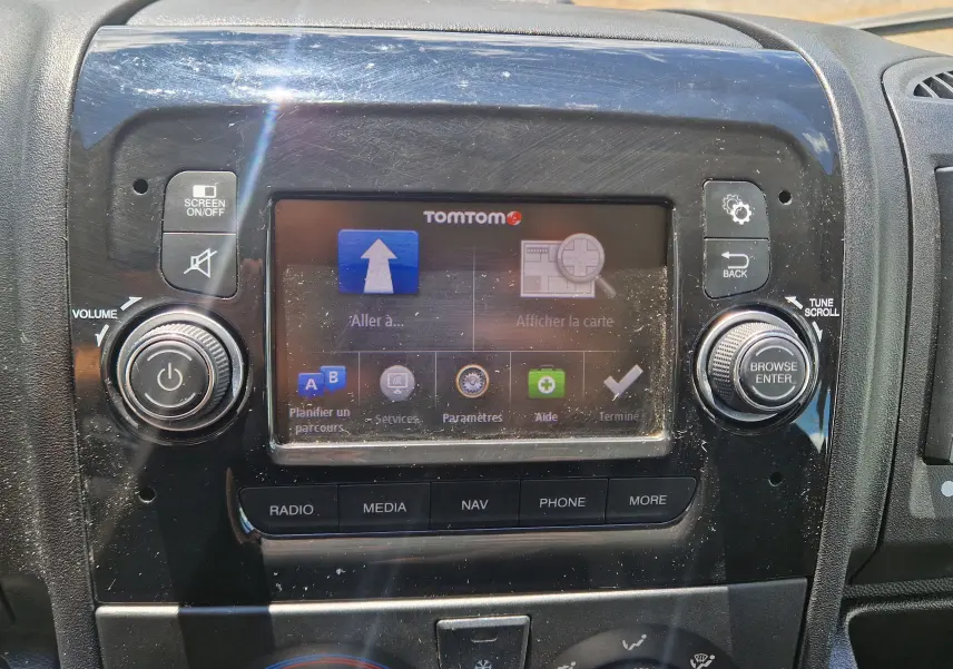 Vue rapprochée de l’écran tactile central noir du Citroën Jumper avec navigation TomTom affichée.