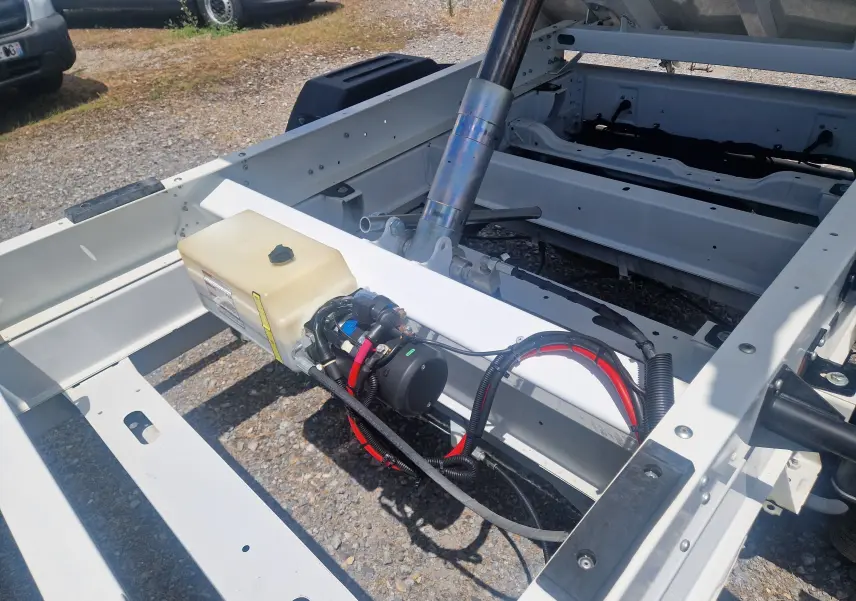 Vue rapprochée du châssis blanc du Citroën Jumper L3 benne, montrant la structure métallique et les câbles électriques.
