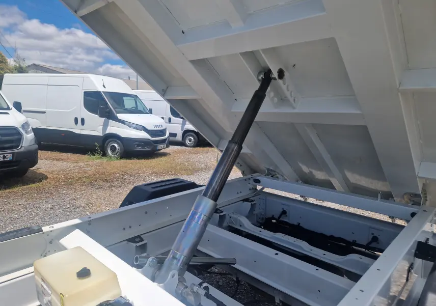 Vue rapprochée du mécanisme de levage de la benne blanche relevée du Citroën Jumper Chassis Double Cabine L3.
