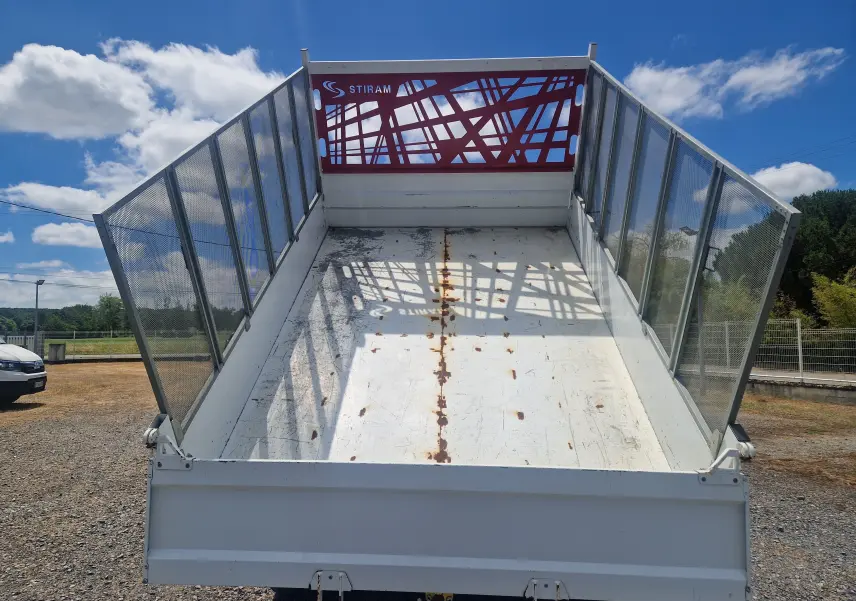 Vue arrière en contre-plongée de la benne blanche relevée avec ridelles grillagées sur Citroën Jumper Chassis Double Cabine.