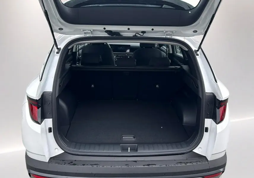 Coffre ouvert vu de l'arrière d'un Hyundai Tucson blanc 2026, montrant l'espace de chargement vide.
