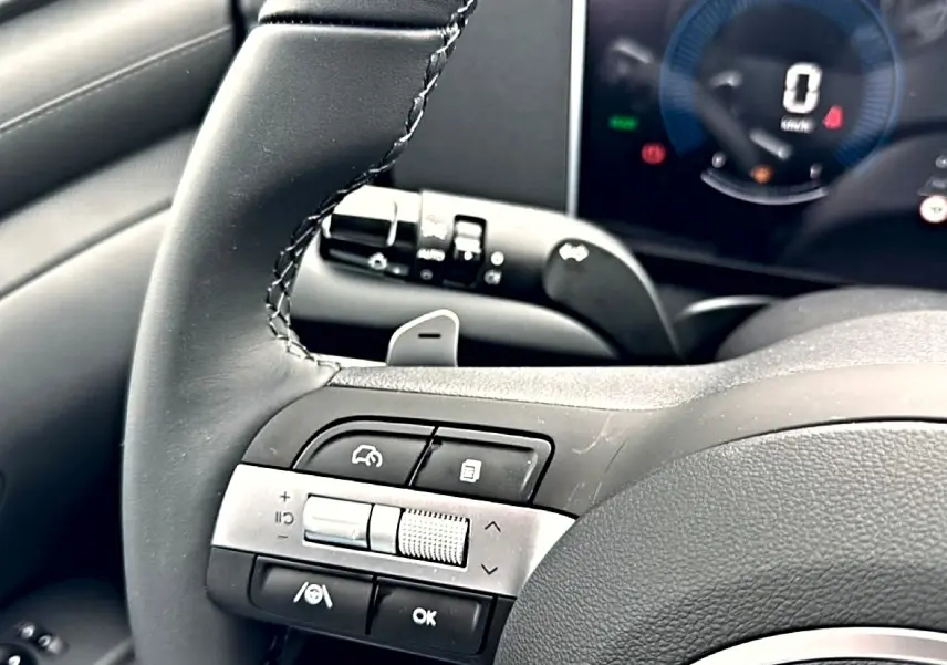 Gros plan sur le volant cuir multifonction noir du Hyundai Tucson 2026 avec commandes intégrées et tableau de bord numérique.