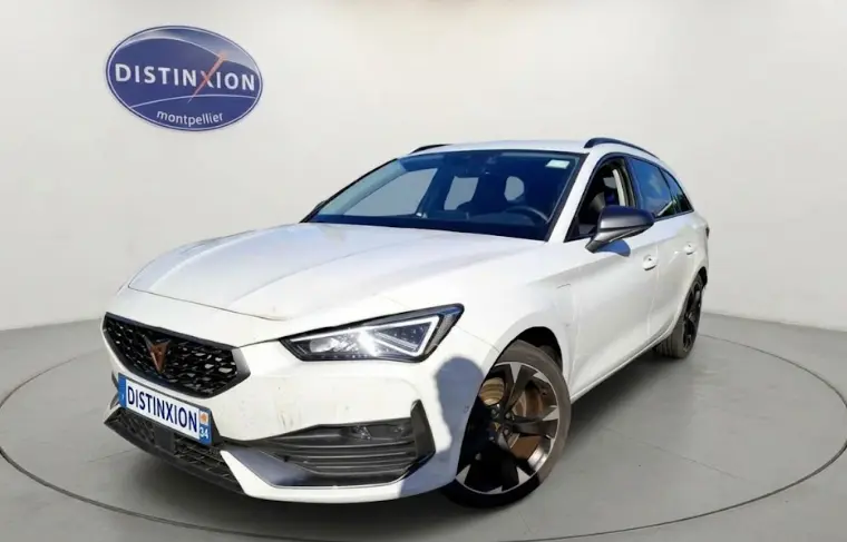 Vue 3/4 avant droite d'une CUPRA Leon Sportstourer blanche 2024 avec jantes noires et calandre noire distinctive.