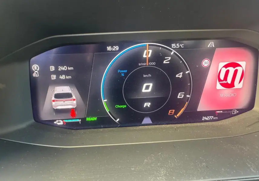 Tableau de bord numérique de la CUPRA Leon Sportstourer blanc, affichant vitesse, autonomie et radio en vue frontale.