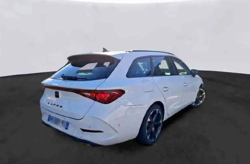 Vue 3/4 arrière droite d'une CUPRA Leon Sportstourer blanche 2024 avec feux arrière reliés et jantes noires distinctives.