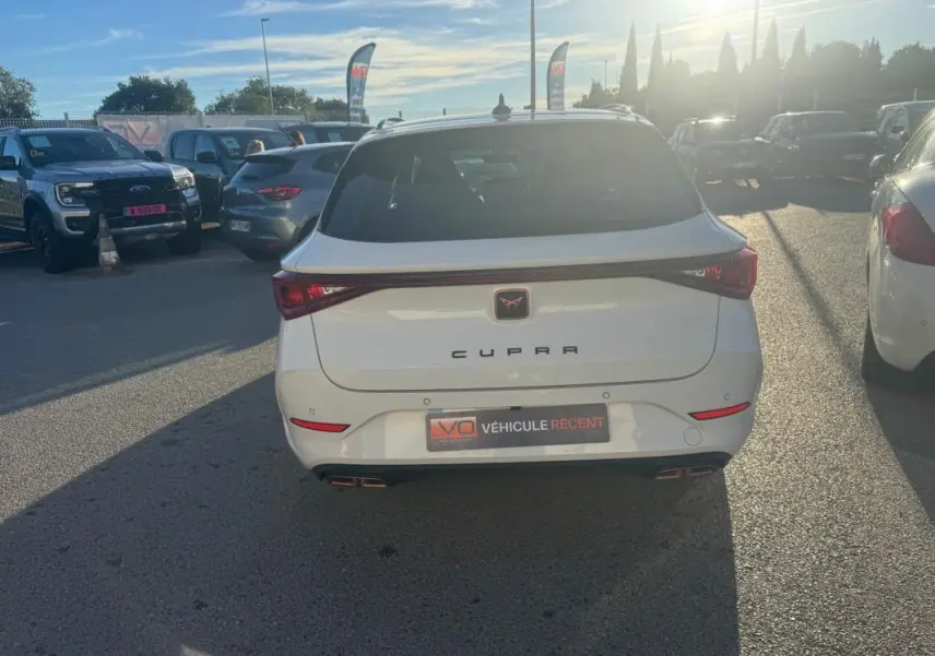 Vue arrière d’un CUPRA Leon Sportstourer blanc 2024 avec feux reliés et double sortie d’échappement intégrée.