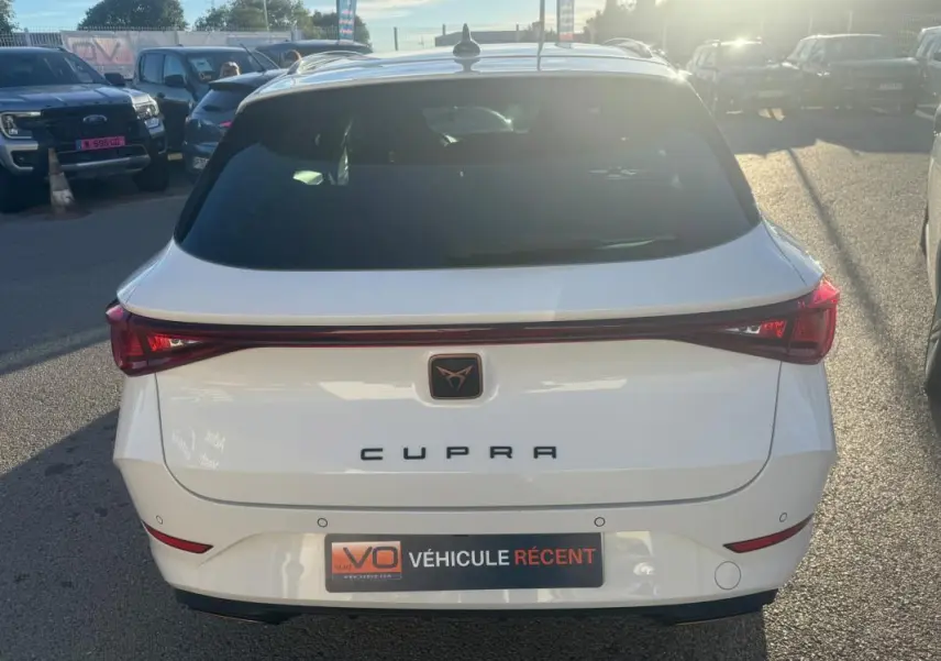 Vue arrière d'une CUPRA Leon Sportstourer blanche 2024 avec feu arrière continu et logo CUPRA central.