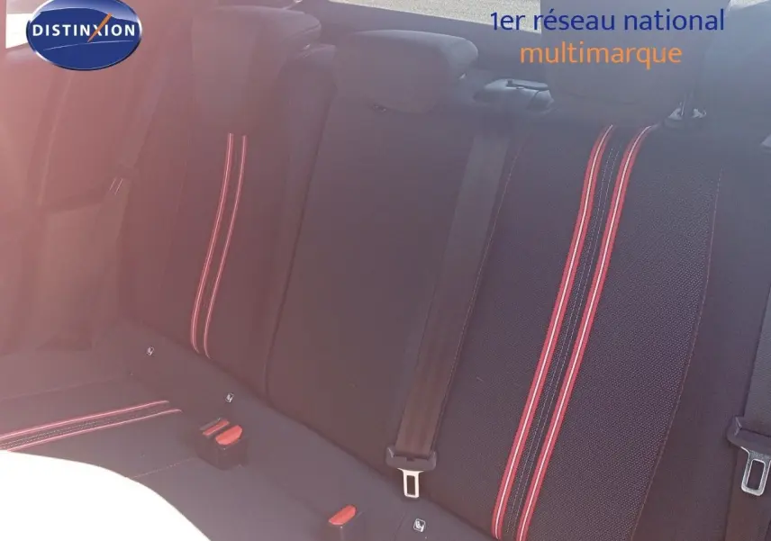 Vue intérieure des sièges arrière noirs de l'Opel Corsa 2023 avec surpiqûres rouges et ceintures de sécurité visibles.